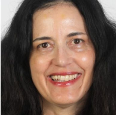 Smiling woman with long dark hair and bright eyes.