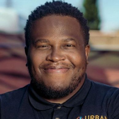 Smiling man outdoors in a black shirt.