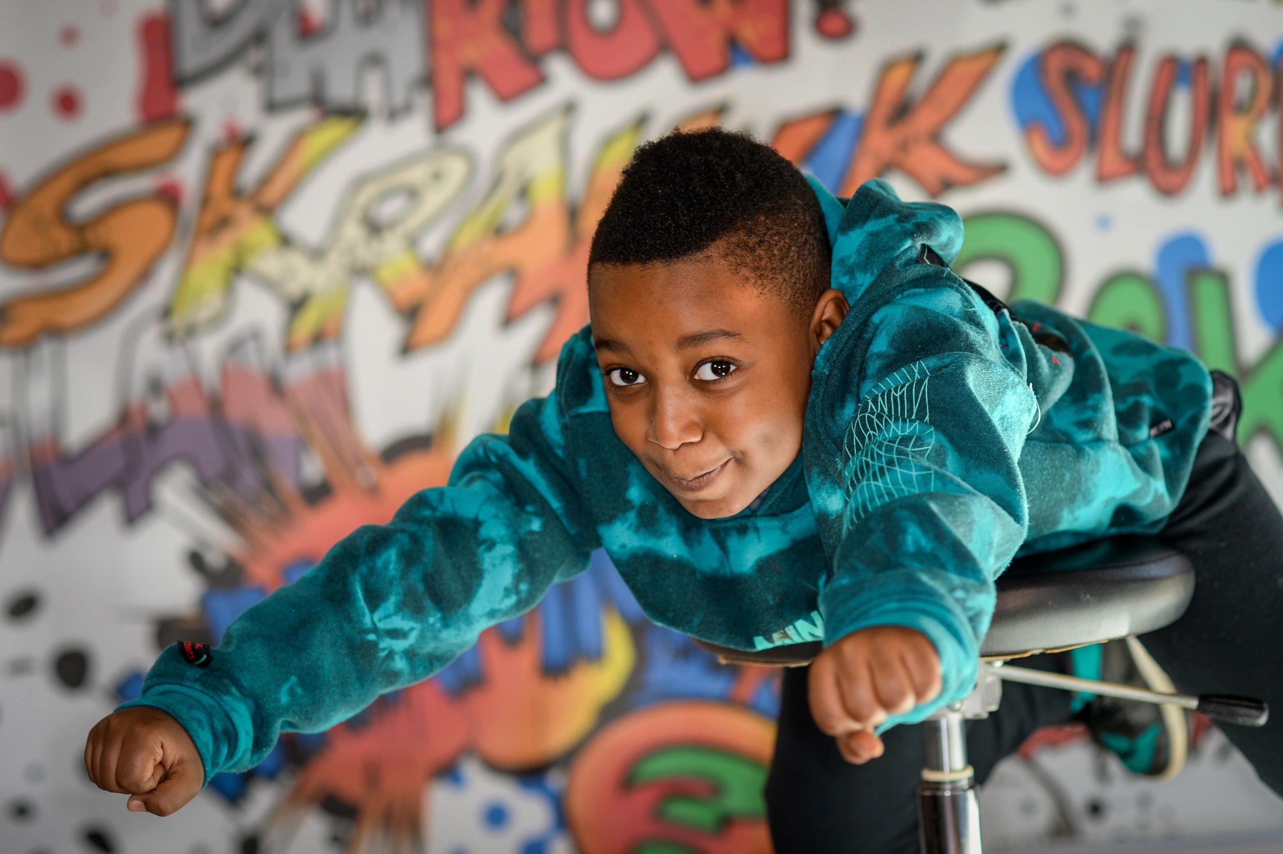 Photo of child flying in front of super hero backdrop