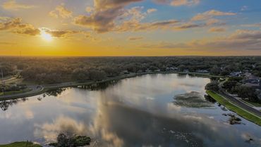 Aerial photograph of sunset over small community lake