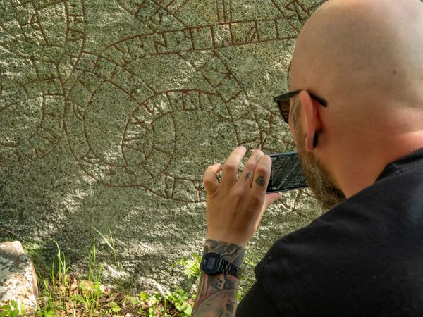 SN caught quickly documenting a detail on the Ågersta rune stone (U 729).