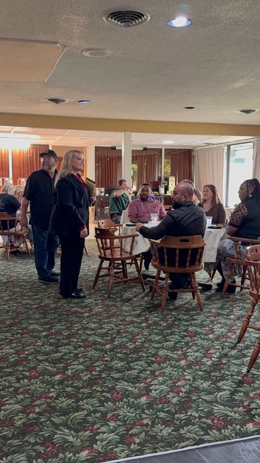 A group of people dining and conversing in a cozy restaurant.