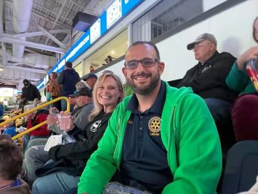 Smiling friends enjoy a lively event from stadium seats.