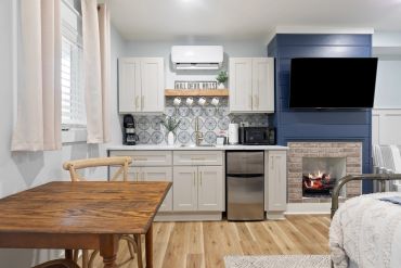 Cozy kitchen and living area with fireplace and wall-mounted TV.