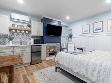 Cozy bedroom with a kitchenette and fireplace.