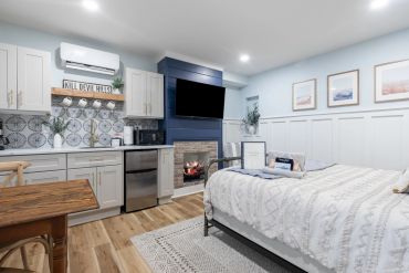Cozy bedroom with kitchenette and fireplace.