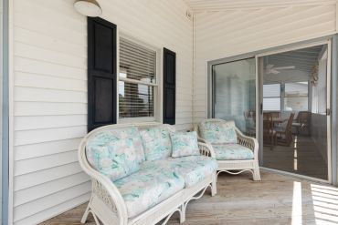 Cozy porch seating with floral cushions.