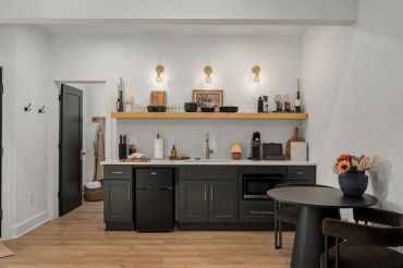 Modern kitchenette with dark cabinets and wood accents.