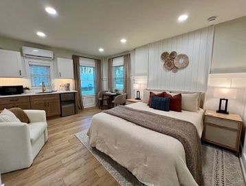 Modern studio apartment with bed and kitchenette.