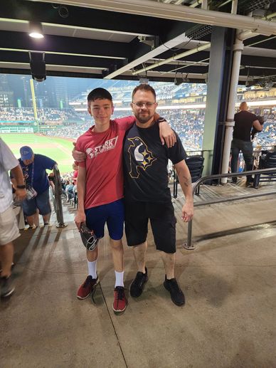 Two people posing at a baseball stadium.