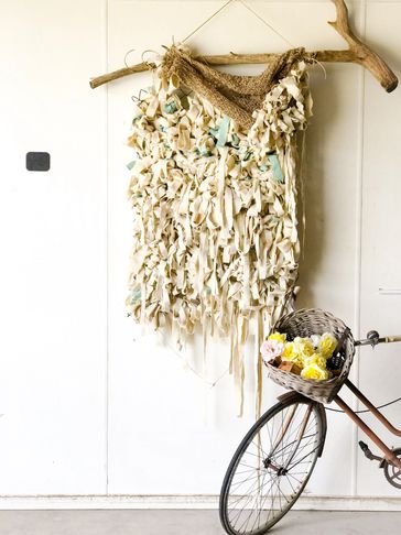 Decorative wall hanging with a bicycle and basket of flowers.