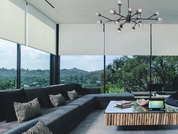 Living room with floor to ceiling windows showing automated, motorized shades lowered slightly
