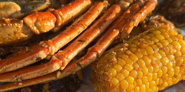 Close-up of seasoned seafood and corn on a plate.