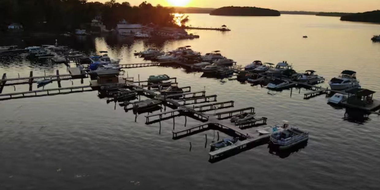 Sunset over a marina filled with boats docked along wooden piers.