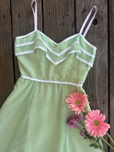 Light green polka dot dress with white trim and pink flowers.