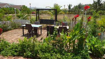 Garden sit-out area with beautiful flowers and swing.