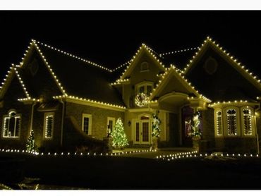 Decor of warm white lights LED for entire roof perimeter and yard with decoration  of trees, window 