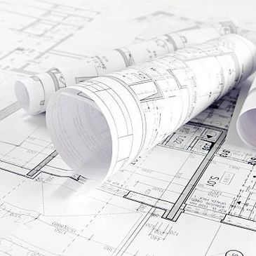 Rolled and flat architectural blueprints on a table.