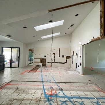 Room under renovation with exposed wires and marked floor.
