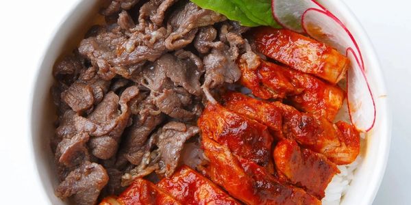 Rice bowl with grilled beef, spicy chicken, fresh greens, and radish slices.