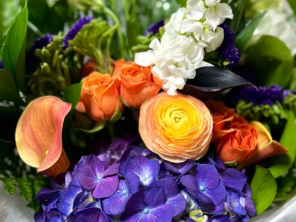 Floral bouquet with violets orange Cala lily  roses white gladiola. Copyright Solediligence.com 2023