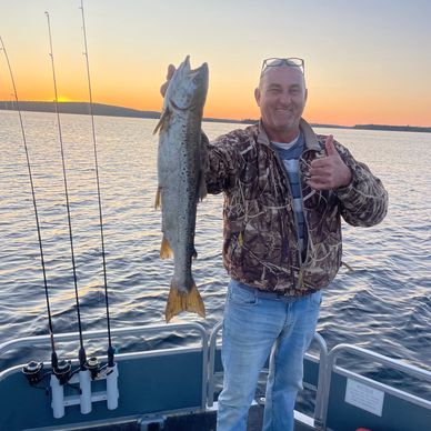 Maine Guide Outfitter sport catches salmon with guide trolling on a Maine Lake. 