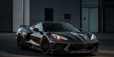 Black sports car parked in a dark setting.