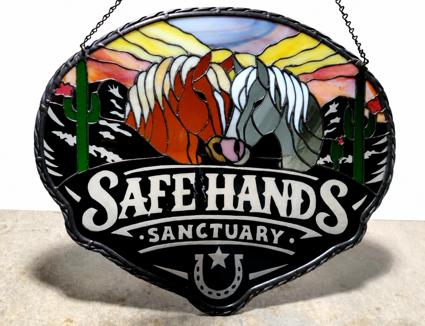 Stained glass sign with horses and text "Safe Hands Sanctuary".
