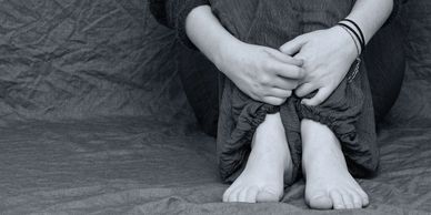 Black and white photo of a girl showing her hands and feet