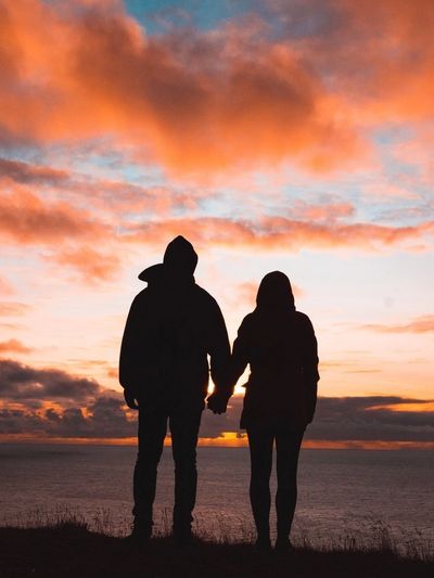 A couple overlooking the ocean at sunrise