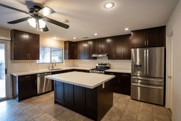 After kitchen remodel Las Vegas - dark espresso cabinets with white quartz countertops and updated i