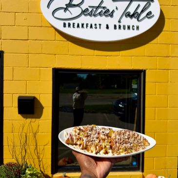 Hand holding a waffle plate outside Besties' Table cafe.