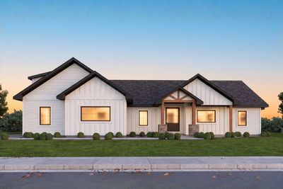 Modern single-story house with white siding and black roof at sunset.