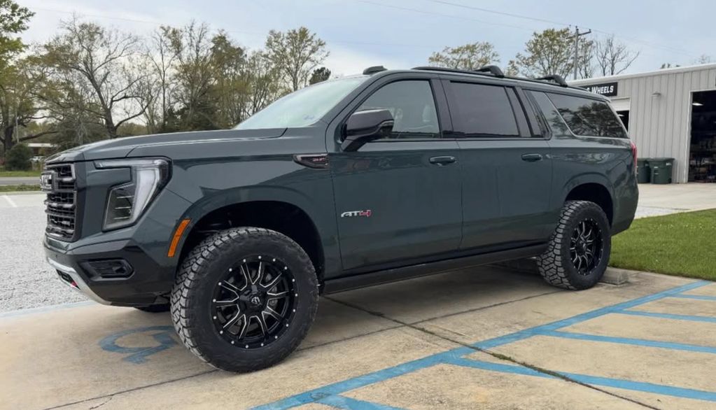 Black GMC SUV parked in a handicap spot near a garage.