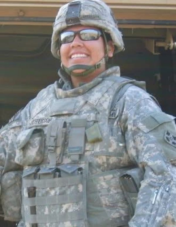 Smiling soldier in full military gear.