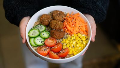 Ensalada colorida con falafel, pepino, maíz, tomate y zanahoria.