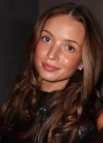 Young woman with long brown hair smiling gently.