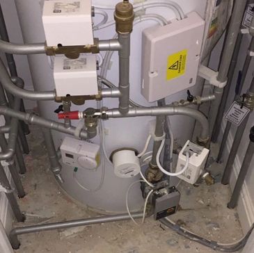 Unvented hot water cylinder with control valves and pipework during routine service in London
