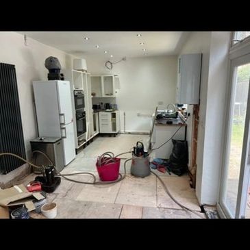 Power flush setup in kitchen during central heating system cleaning with professional equipment