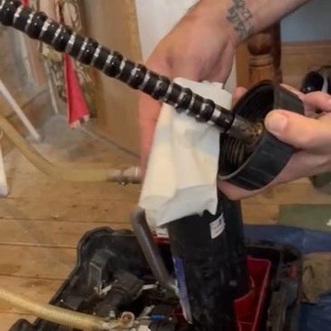 MagnaCleanse filter being wiped clean during power flush to remove central heating sludge buildup