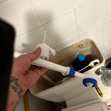 Toilet cistern fill valve being replaced during plumbing repair
