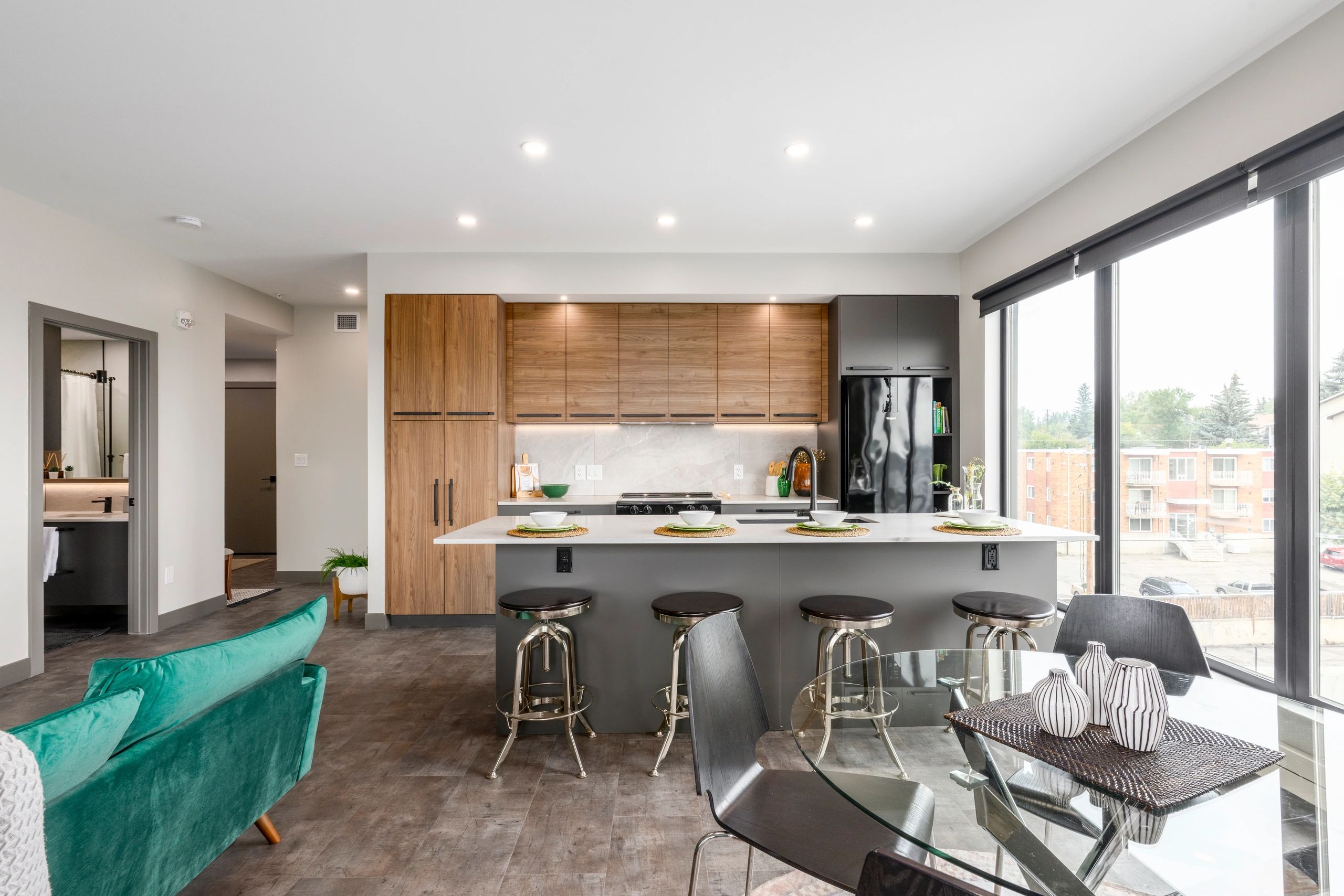 Modern kitchen with wood cabinets and bar stools.