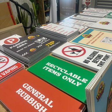 Various printed signs for parking, recycling, and rules on display.