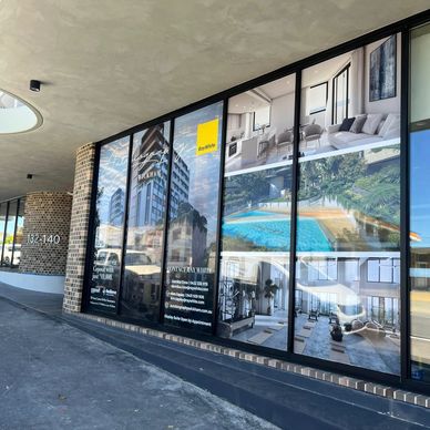 Large window posters advertising apartments with images of interiors and a pool.