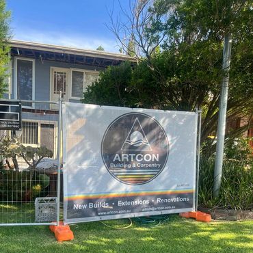 Construction site with ARTCON Building & Carpentry banner.