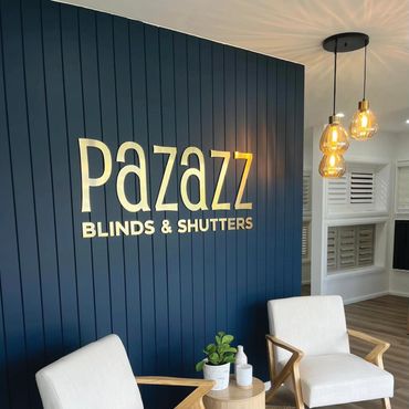 Brushed gold acrylic sign on blue wall in reception.