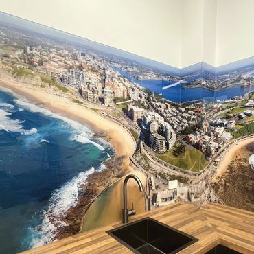 Kitchen splashback with aerial coastline image.