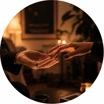 Two hands reaching out to each other in a warm, cozy setting.