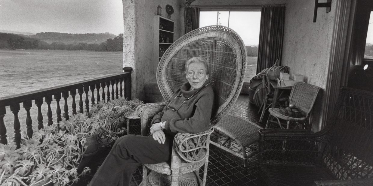 Black and white photograph of M.F.K. Fisher seated on the front terrace of Last House.