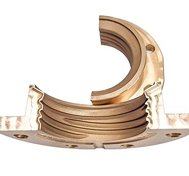 Close-up of a bronze mechanical component with grooves and holes.